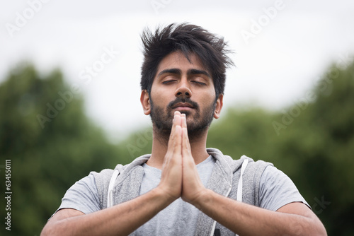 Indian man doing yoga exercise in a park