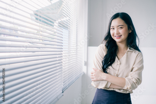 Free Download Portrait of smiling young asian woman looking at camera with arms crossed. Modern business asian woman. Successful businesswoman standing in office with copy space.  - GFXLoad