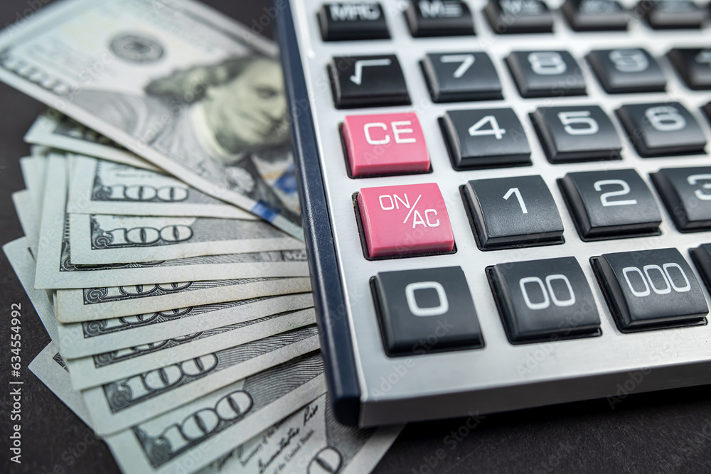 Money dollars and calculator isolated on black background. the concept of economics. Money dollars and calculator isolated on black background. the concept of economics.