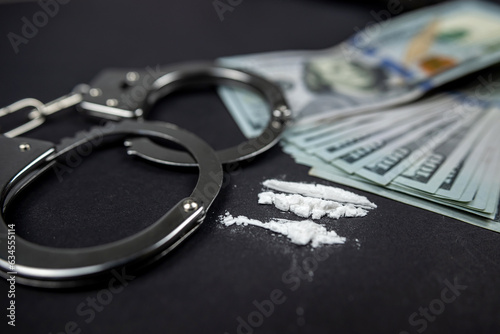 Fotografi Plastic bags of cocaine or heroin and US dollar bills with handcuffs and bullets from a gun