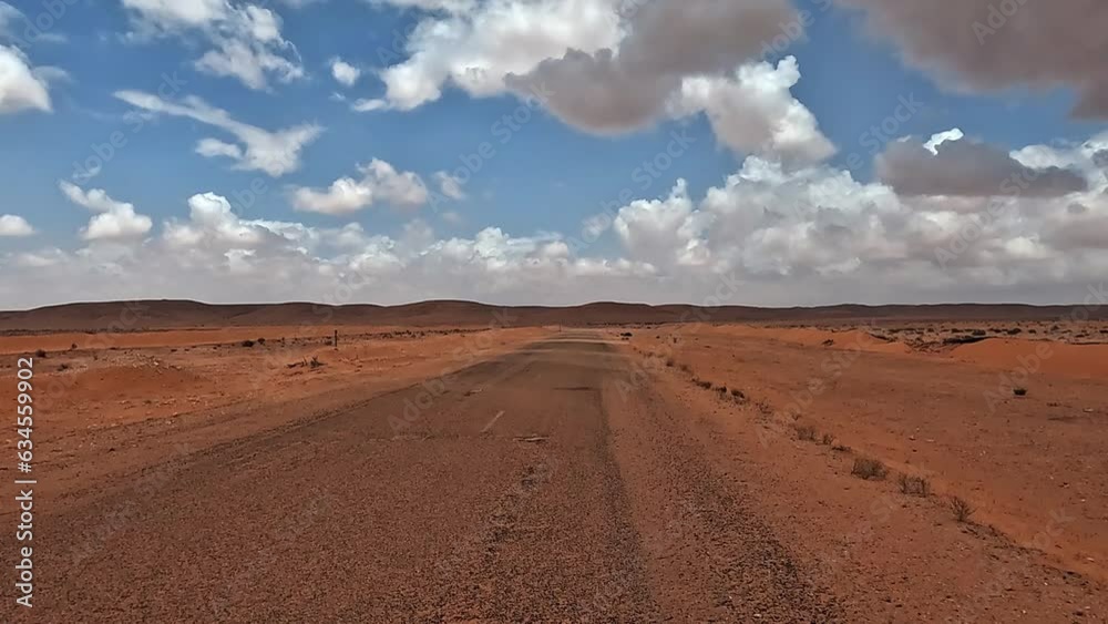Car POV driving on Tunisia desert road with clouds in blue sky Car POV driving on Tunisia desert road with clouds in blue sky