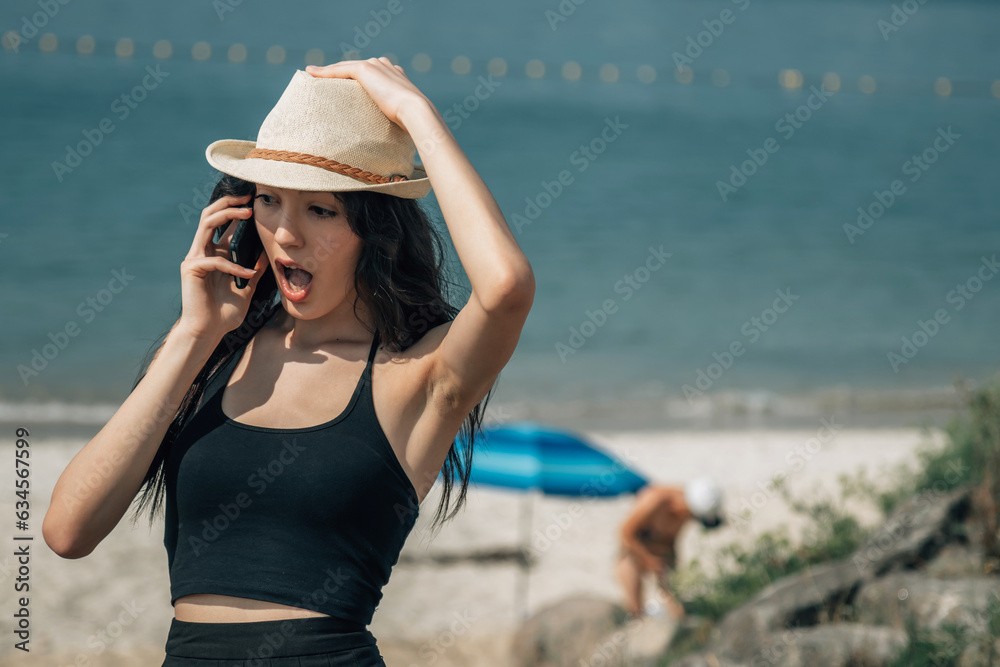 surprised girl on the beach with mobile phone
