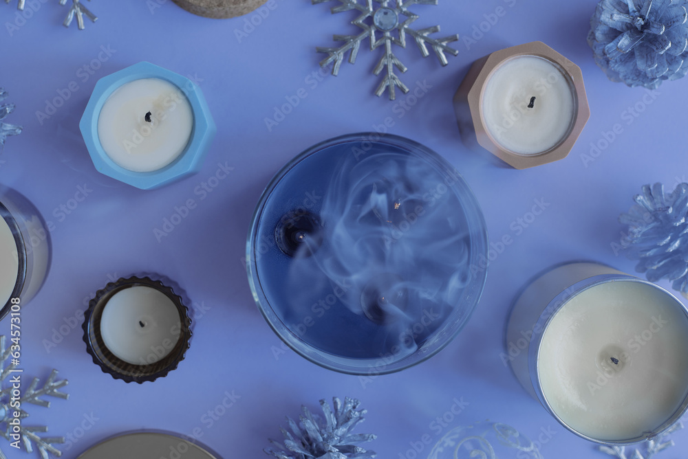 Candles on blue background, top view. Christmas and winter season concept. Smoldering candle Candles on blue background, top view. Christmas and winter season concept. Smoldering candle