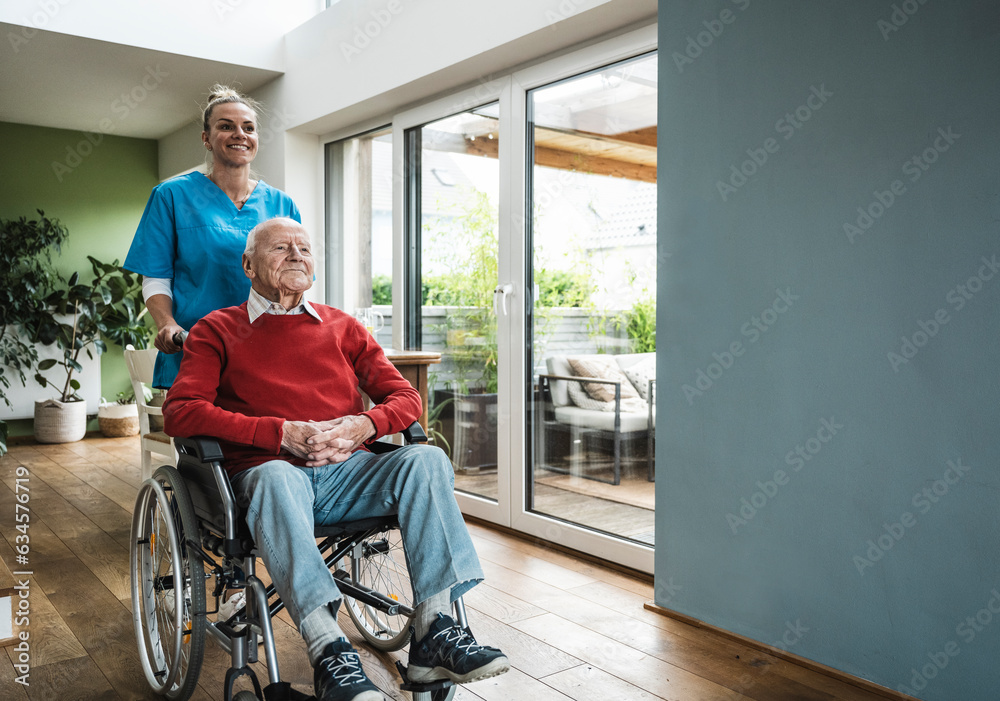 Happy nurse taking care of senior man sitting in wheelchair at home Happy nurse taking care of senior man sitting in wheelchair at home