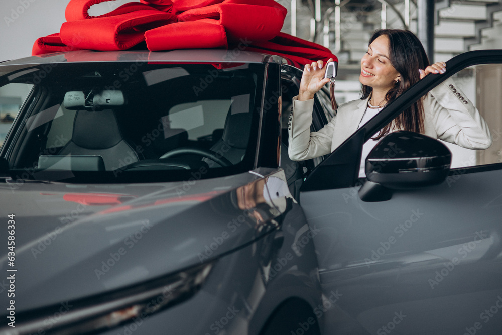 Woman holding keys by her new car