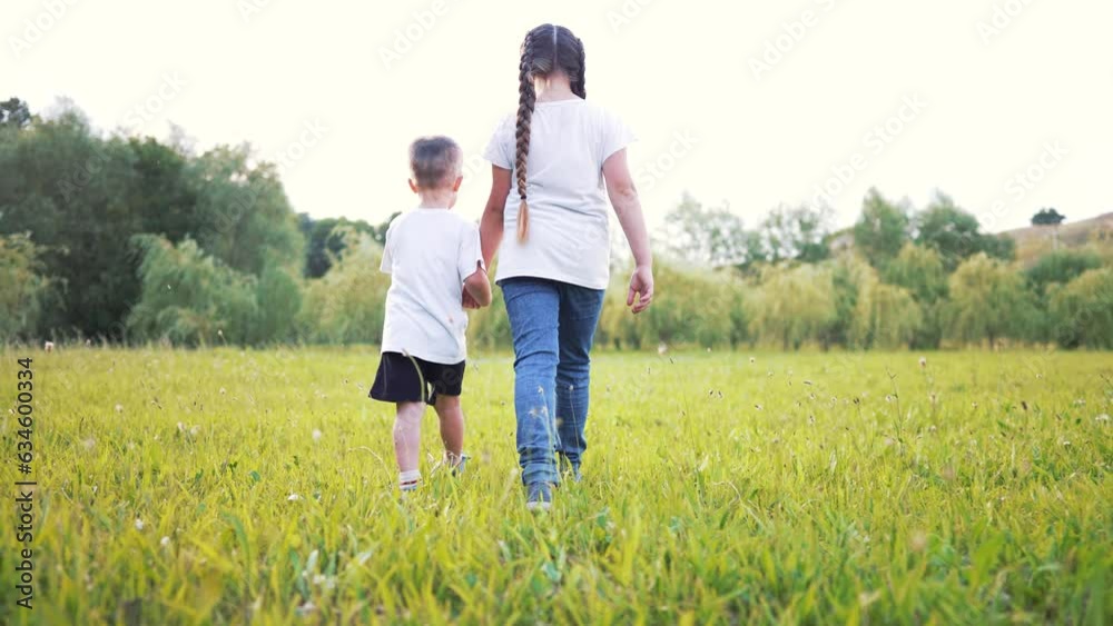 kids walk with pet dog on green grass in park at sunset.happy family kids have fun on grass on green lawn. Summer vacation picnic outdoors in park walking tour.Happy family and childhood dream concept kids walk with pet dog on green grass in park at sunset.happy family kids have fun on grass on green lawn. Summer vacation picnic outdoors in park walking tour.Happy family and childhood dream concept