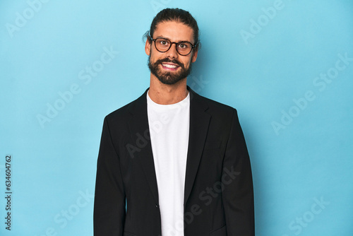 Businessman in suit with eyeglasses and beard happy, smiling and cheerful.