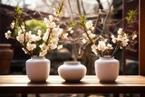 Three white vases sitting on top of wooden table.