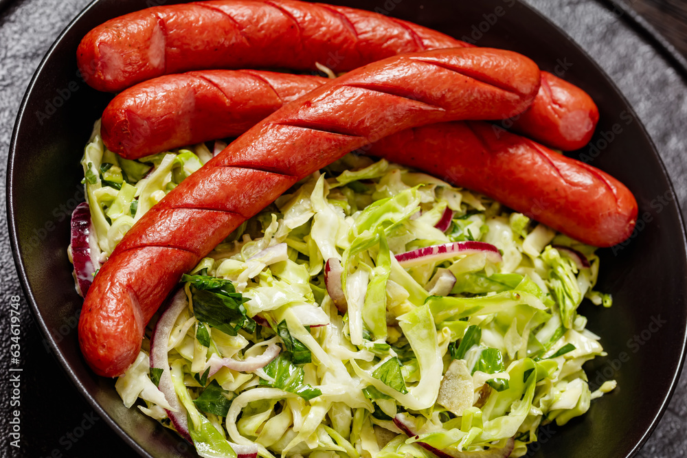 cooked sausages with coleslaw salad in black bowl cooked sausages with coleslaw salad in black bowl