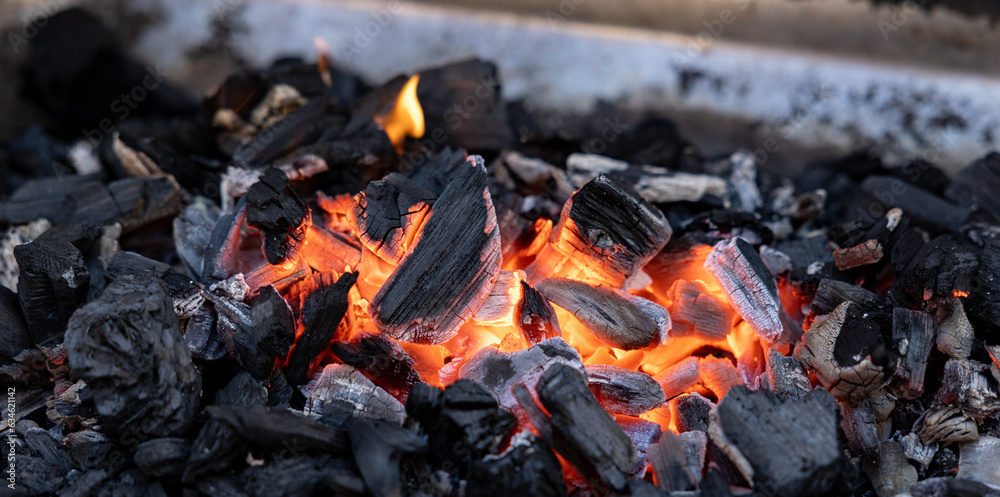 Ember of charcoal on a barbeque grill. Close-up of fire, glowing charcoal and hot embers. Summer, heat, temperature, leisure activity, outdoors, barbecue season. Ember of charcoal on a barbeque grill. Close-up of fire, glowing charcoal and hot embers. Summer, heat, temperature, leisure activity, outdoors, barbecue season.