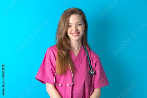 Close up photo of Young caucasian doctor woman wearing pink medical uniform toothy smiling