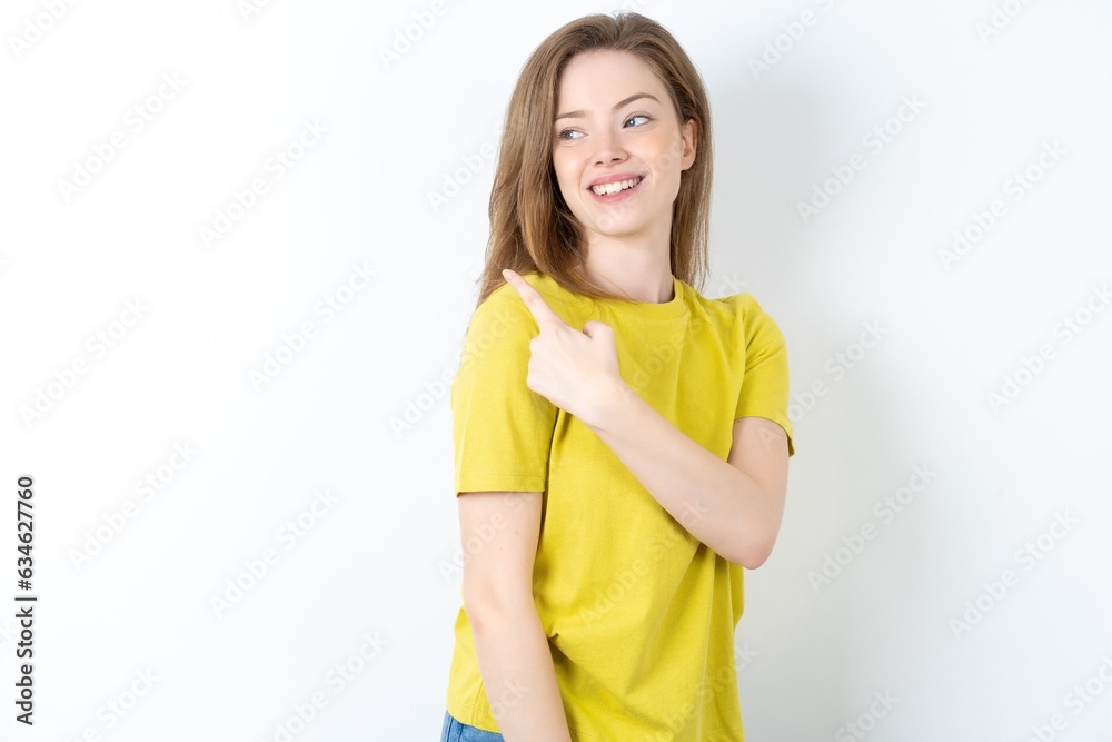 Young beautiful girl wearing yellow T-shirt glad cheery demonstrating copy space look novelty Young beautiful girl wearing yellow T-shirt glad cheery demonstrating copy space look novelty