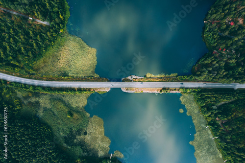 Foto Aerial view of bridge asphalt road with cars and blue water lake and green woods in Finland