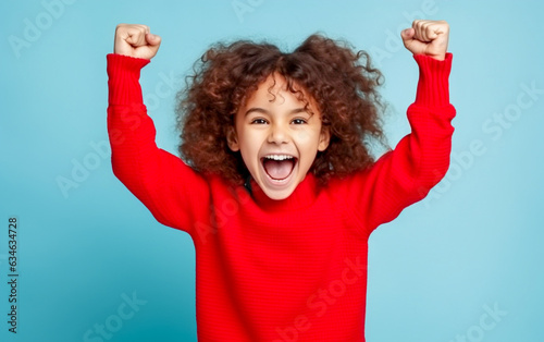 A little baby girl exultation with his fists raised and a joyful expression - isolated on the background