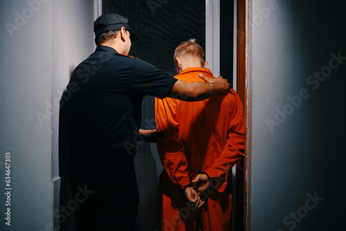 Police officer walking suspect to interrogation room, view from the back