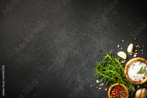 Ingredients for cooking on black stone kitchen table. Herbs, spices and vegetables. Top view with space for design.