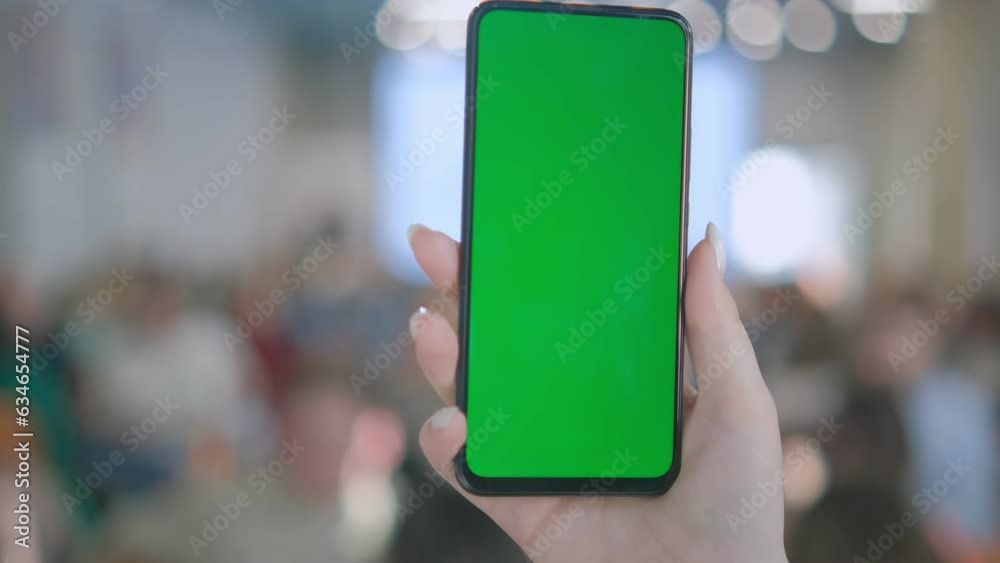 A woman with a smartphone in her hand. Point of View of Woman at Phone with Green Screen for Copy Space. The concept of a successful business woman, feminism. Close-up. A woman with a smartphone in her hand. Point of View of Woman at Phone with Green Screen for Copy Space. The concept of a successful business woman, feminism. Close-up.