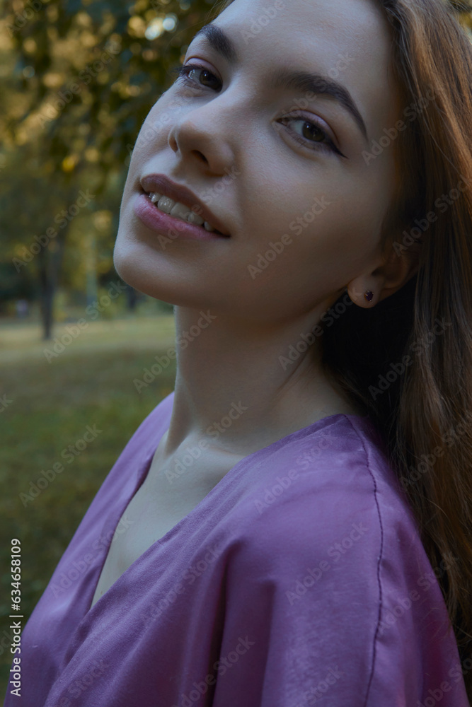 a beautiful, relaxed woman walks in the park in a purple dress, enjoying her vacation a beautiful, relaxed woman walks in the park in a purple dress, enjoying her vacation