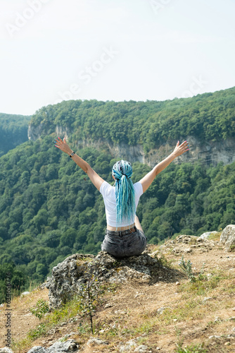 beautiful young woman with afro locks hiking in mountains