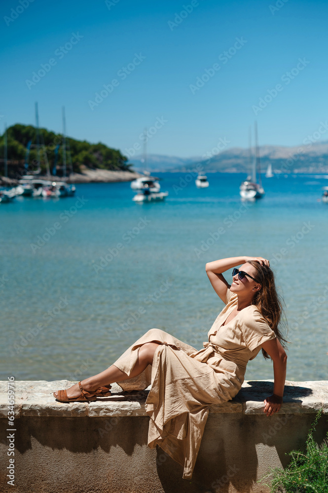 Lady sitting on curb with stunning seascape background