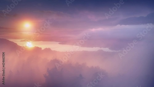 Aerial shot of beautiful, coloured misty sunset with clouds, camera moves into amazing, epic landscape of sunset at sea