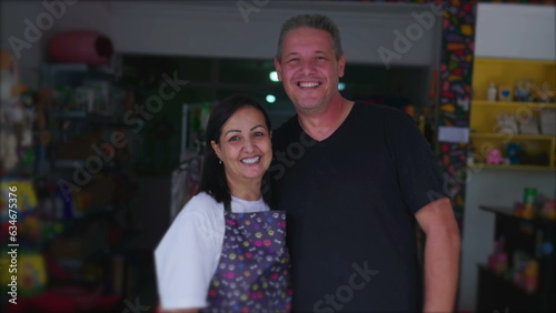 Authentic joyful couple owners of Small Local Business posing for camera smiling. Brazilian Entrepreneurs of Pet Shop in storefront photo