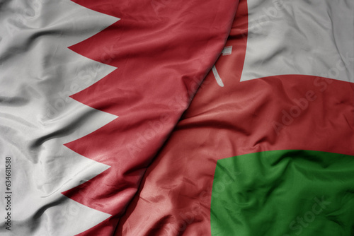 big waving realistic national colorful flag of bahrain and national flag of oman .