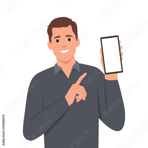 Stylish young businessman in vest suit showing blank mobile, cell phone and pointing finger. Trendy person holding smartphone screen.