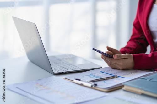 Female accountant analyzing charts, graphs, computer, investment tablet and pressing calculator button above document. Accountants, accountants, clerks, bank consultants and auditors. close-up photo