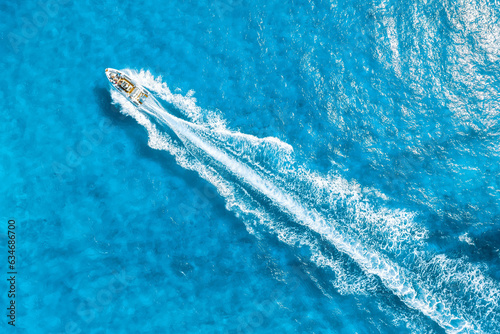 Aerial view on fast boat on azure Mediterranean sea at sunny day. Fast ship on the sea surface. Seascape from the drone. Seascape with motorboat. Vacation and leisure. © biletskiyevgeniy.com