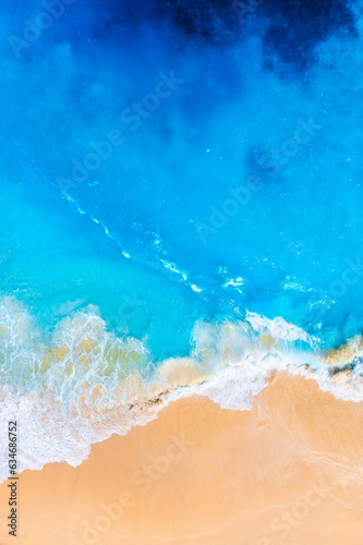 Waves and beach from a drone. Aerial landscape. Blue water background from drone. Summer seascape from air. Coast as a background from top view. Vacation time.