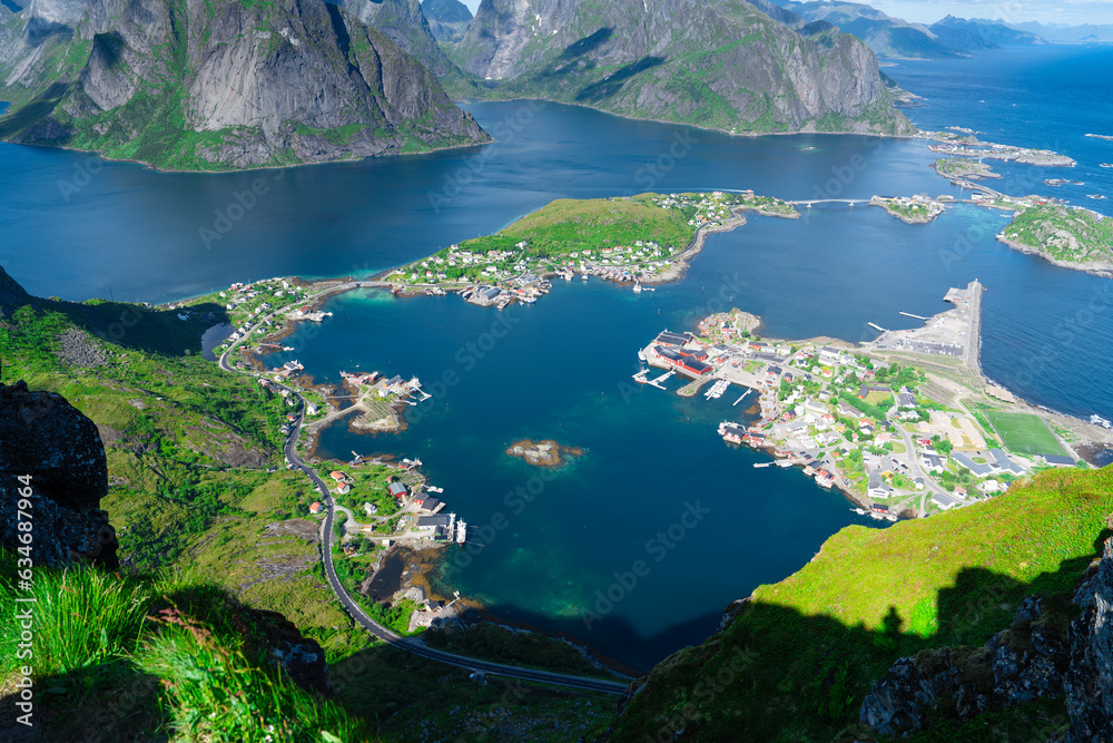 Amazing view from Reinebringen view point. Mountains and blue sea at Lofoten islands. Scenery of Reine fishing village. One of most popular hiking trails in North of Norway.