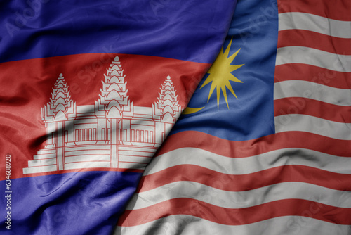 Photography big waving realistic national colorful flag of cambodia and national flag of malaysia