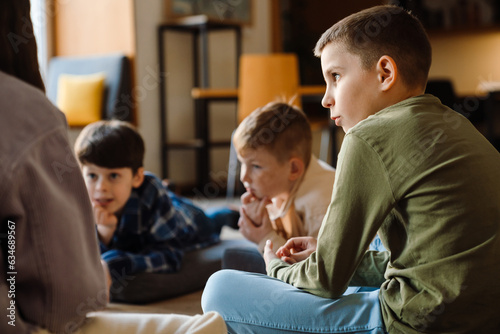 Group of kids discussing something while sitting in classroom