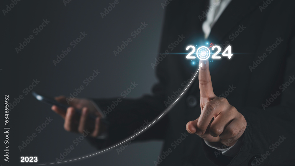 Fototapeta premium Arrow start from 2023 to 2024 new year target plan of growth success business. Businessman draws increase arrow line. Plans and Visions for Next Year, opportunity, challenge and business strategy.