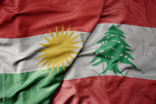 big waving realistic national colorful flag of kurdistan and national flag of lebanon . photo