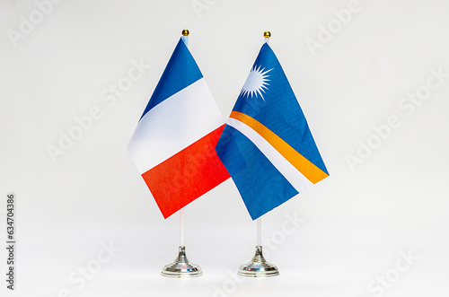 State flags of France and the Marshall Islands on a light background. photo