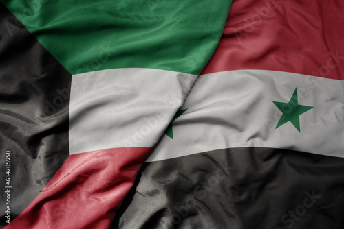 big waving realistic national colorful flag of kuwait and national flag of syria .