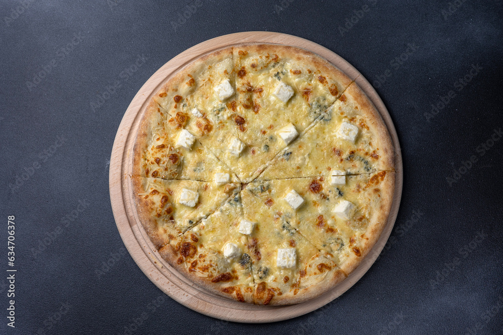 Italian cuisine. Delicious pizza on a dark background Italian cuisine. Delicious pizza on a dark background