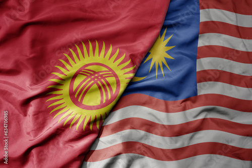 big waving realistic national colorful flag of kyrgyzstan and national flag of malaysia .