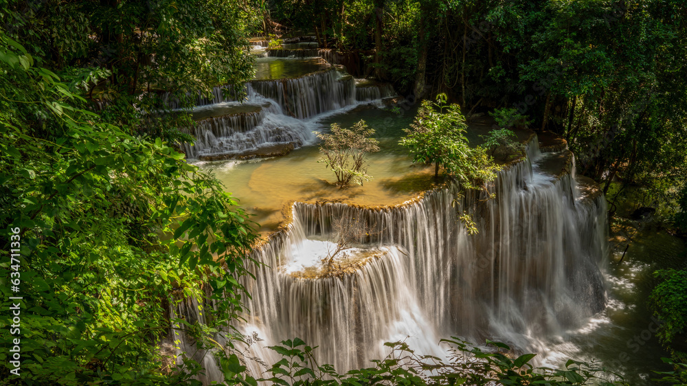 Obraz premium beautiful water fall and Leaf natural leaves and stream green forest in the mountain concept back ground cover page environment ecology or nature wallpape