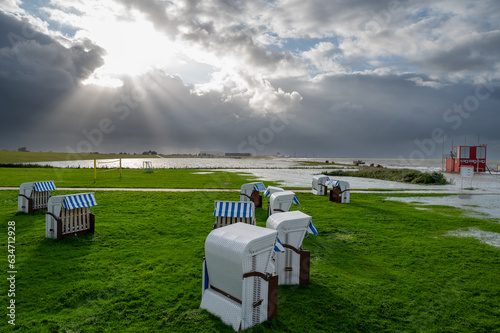 Beach chairs at the beach of Altenbruch near Cuxhaven in Germany. Beach flooded after a summer storm. photo