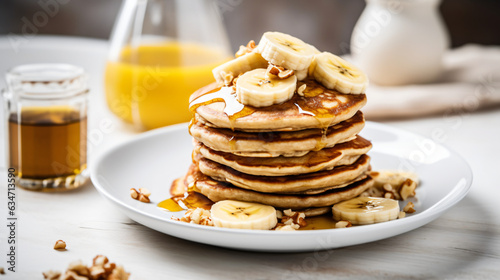 A stack of oatmeal banana pancakes topped with fresh banana slices, walnuts, and honey, accompanied by a cup of tea on a white wooden background. A nutritious breakfast. Space for copy. generative AI