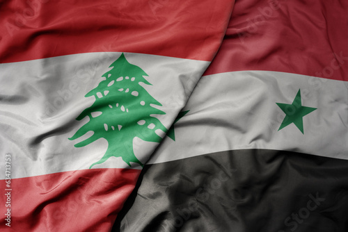 big waving realistic national colorful flag of lebanon and national flag of syria . photo