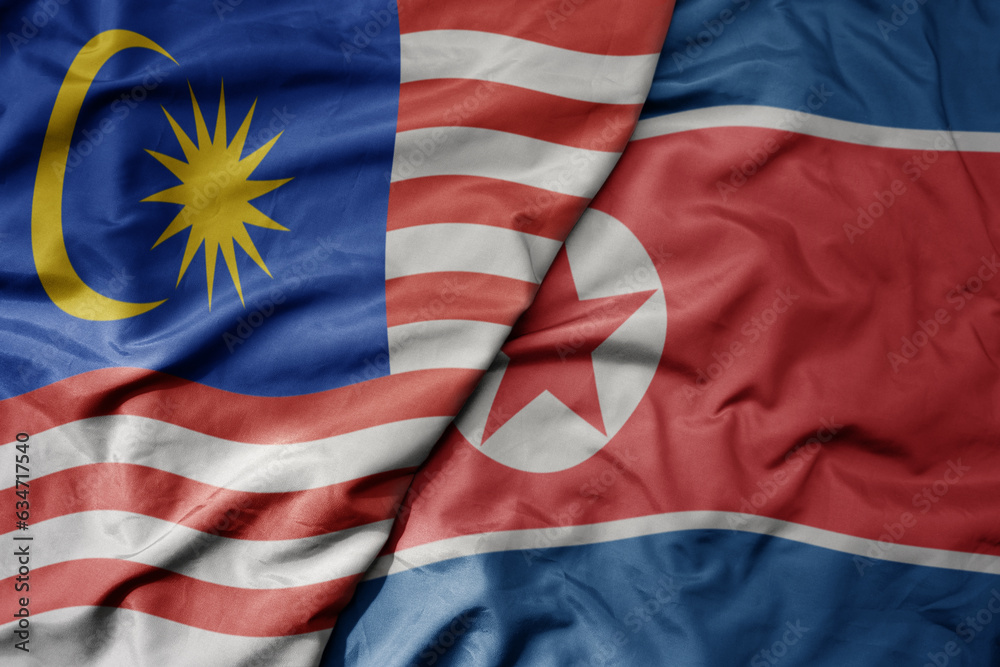 big waving realistic national colorful flag of malaysia and national flag of north korea .