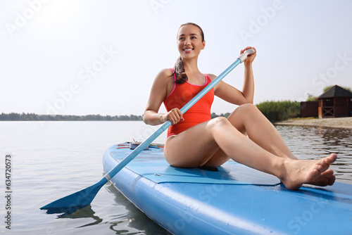 Woman paddle boarding on SUP board in sea