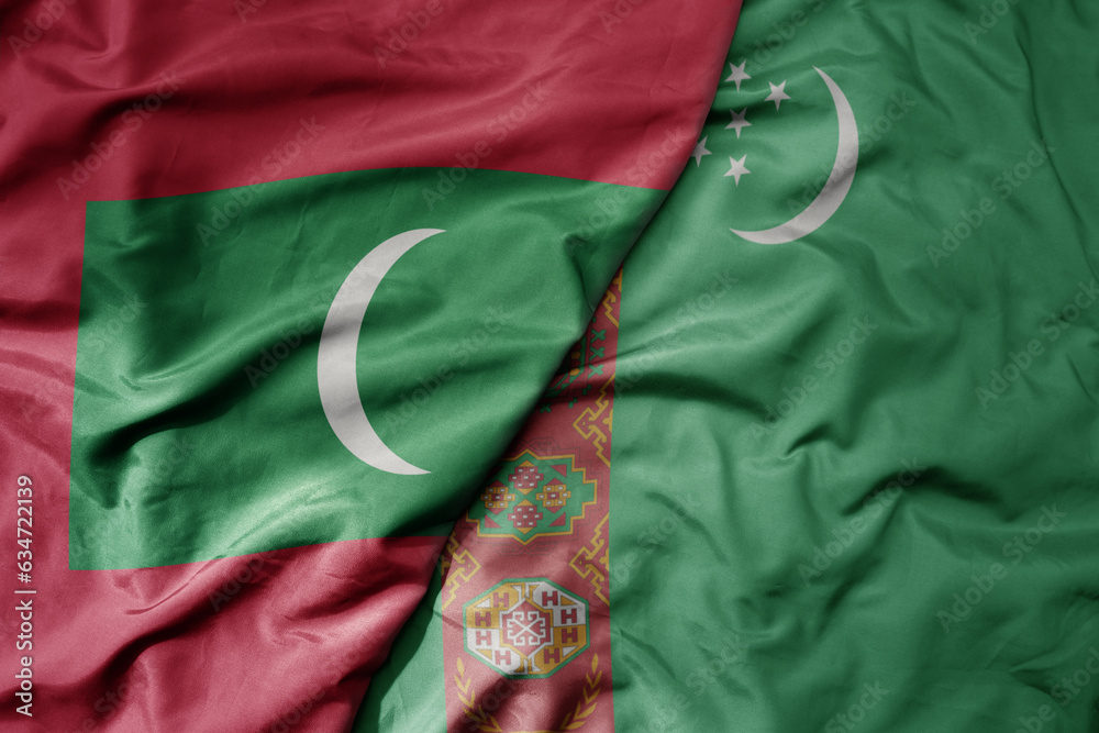 big waving realistic national colorful flag of maldives and national flag of turkmenistan .