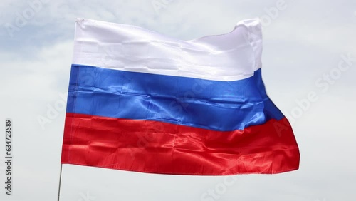 Close-up of the national flag of the Russian Federation fluttering in the wind against a white cloudy sky. High quality 4k footage photo