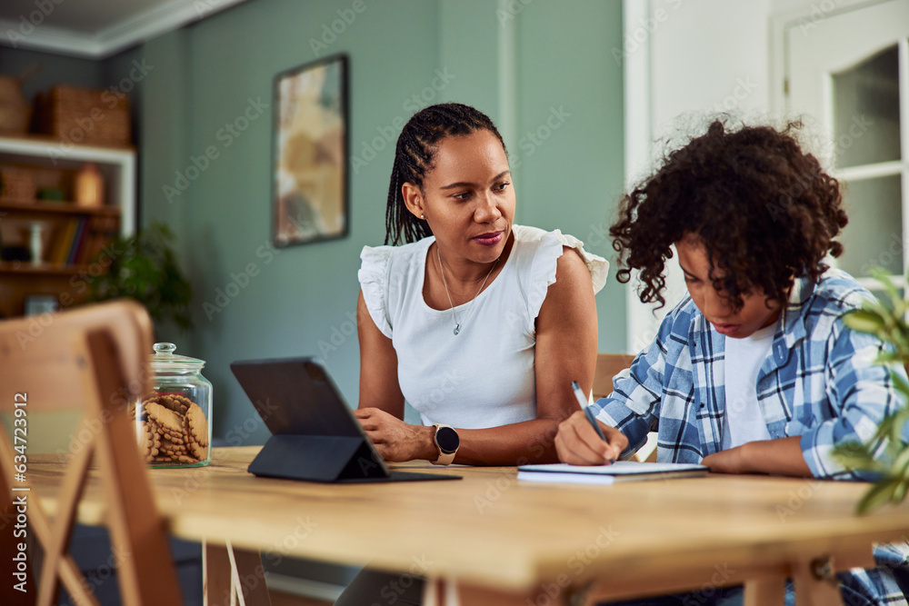 African American woman overseeing a teenager who is doing his homework. African American woman overseeing a teenager who is doing his homework.