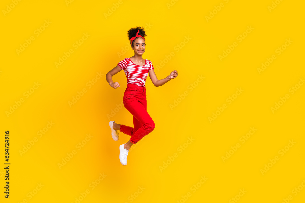 Full body photo of pretty young girl jump run fast hurry sales dressed stylish red striped outfit isolated on yellow color background Full body photo of pretty young girl jump run fast hurry sales dressed stylish red striped outfit isolated on yellow color background